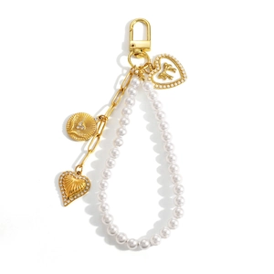 Pearl heart bag charm with gold chain pendants and rhinestones on white background