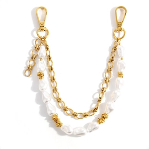 Detailed view of baroque pearl strap with gold chain links and lobster clasp fasteners