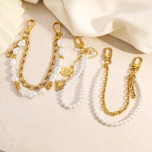 Detail of 18K gold plated bag chains with pearls, heart charms, and lobster clasps