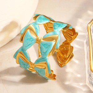 Détail du bracelet papillon plaqué or avec émail bleu et élégant design ajouré chic