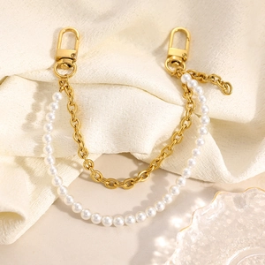 Detail of double-layer bag chain with white pearls and gold metal links and lobster clasps