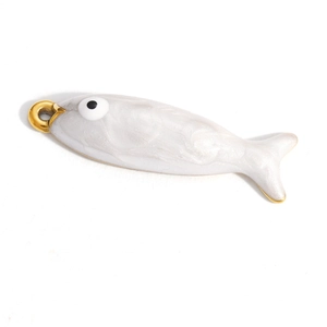Dettaglio di un ciondolo a forma di pesce in smalto bianco perlato con bordi dorati