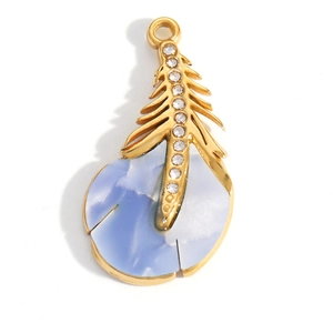Dettaglio di un ciondolo a piuma dorata con resina marmorizzata blu e strass bianchi