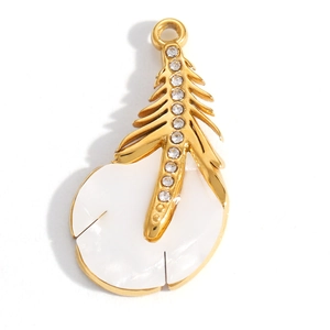 Dettaglio di un ciondolo a foglia d'oro con intarsio in smalto bianco e strass brillanti