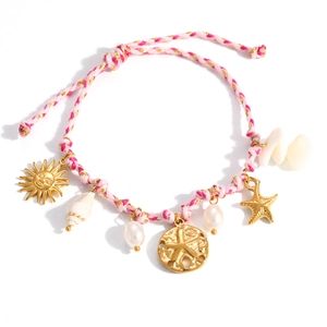 Pulsera tejida rosa con dijes de estrella de mar dorada, caracoles y perlas en detalle macro