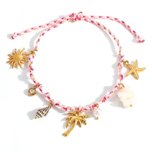 Pulsera náutica trenzada con dijes dorados de conchas estrellas y perlas sobre blanco