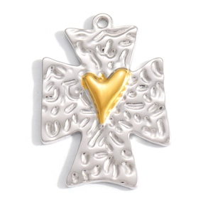 Detail of a retro silver cross pendant with hammered texture and a gold heart accent