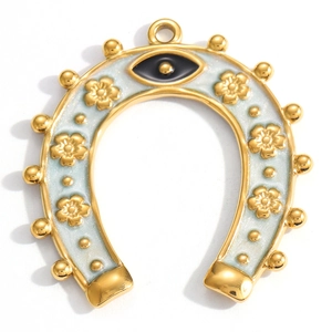 Detailed close-up of golden horseshoe pendant with blue enamel evil eye and floral accents