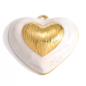 Detailed view of heart-shaped gold pendant with white pearlescent resin inlay and stripes