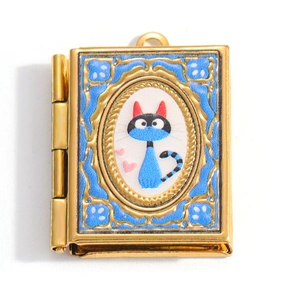 Golden book locket pendant with blue cat illustration and vintage hinge details