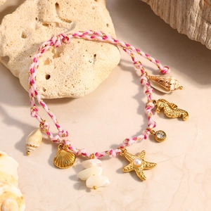 Pulsera tejida océano rosa y blanco con dijes dorados de estrella de mar y conchas