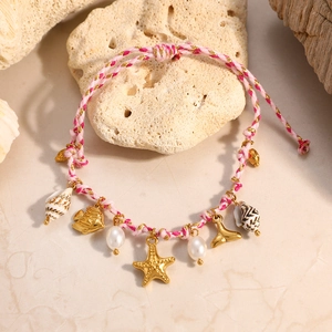 Detalle de una pulsera trenzada rosa de tema marino con colgantes de estrella de mar