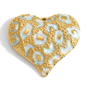 Close-up of heart-shaped gold pendant with mint blue enamel and dot textures