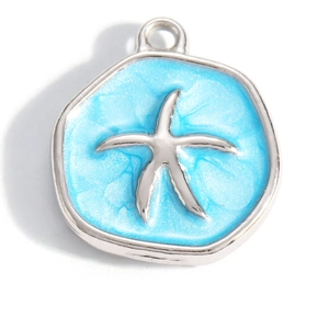 Macro shot of silver metal starfish pendant with glittery blue enamel finish