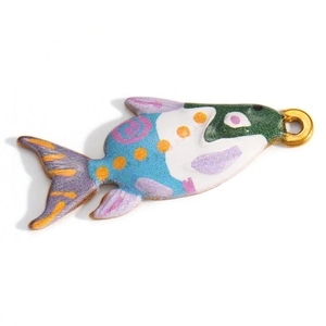 Macro shot of colorful enamel fish pendant with gold ring for jewelry making