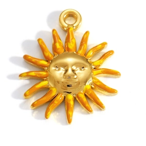 Macro view of 18K gold plated sun pendant with orange enamel rays and humanized face