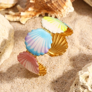 Détail du bracelet coquillage avec émail arc-en-ciel dégradé sur décor de plage