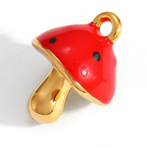 Detail of mushroom pendant with red enamel top and gold plated finish on white background