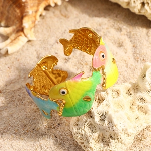 Détail du bracelet ouvert en forme de poisson avec dégradé arc-en-ciel sur sable
