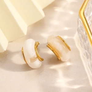 Detailed macro view of C-shaped 18k gold plated earrings with white resin inlay