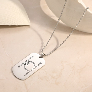 Detailed view of silver stainless steel dog tag necklace with bold engraved artistic slogans
