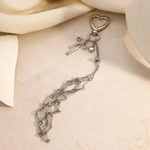 Detail of a heart-shaped metal clasp and tassel chain pendant for bags and keyrings