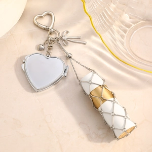 Silver stainless steel heart mirror pendant with mesh bag charm on marble surface