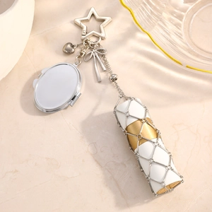 Detail of a silver star clasp with heart and bow charms and a mesh lip balm holder