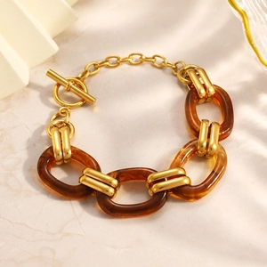 Detail view of gold stainless steel and amber resin chain bracelet with OT toggle clasp