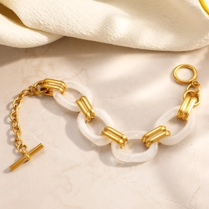 Close-up of gold stainless steel link chain with white resin rings and toggle clasp