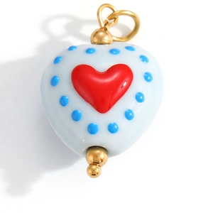 Detail of blue heart-shaped enamel pendant with red center and golden accents