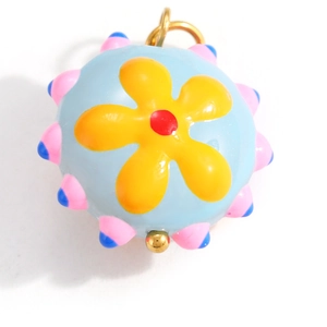 Close-up of a colorful spherical floral pendant with blue enamel and yellow flower charm