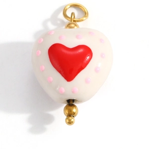 Detailed view of heart-shaped ceramic pendant with red heart and gold metal ring