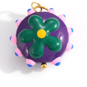 Close-up of a colorful purple floral pendant with pink accents and golden metal ring hook
