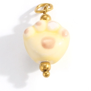 Detailed close-up of a cream ceramic cat paw pendant with pink pads and gold bail