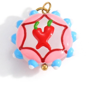 Macro detail of a resin charm with red chili pattern and golden metal loop attachment