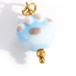 Detail of blue cat paw glass pendant with gold accents on white background