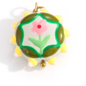 Detailed macro of a vintage 3D floral glass pendant charm with pink flower and green leaf