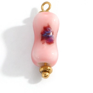 Pink heart patterned resin charm pendant with golden metal ring on white background