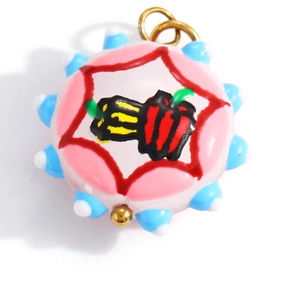 Detail of pink enamel charm with apple pattern and golden metal ring for DIY necklace