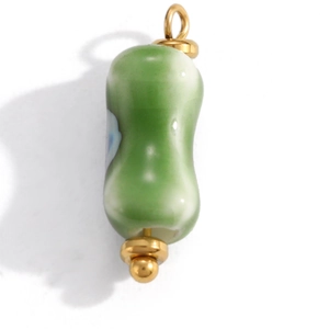 Detail of green and white gradient ceramic pendant with gold metal ring hardware