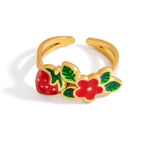 Detail of adjustable gold ring with red enamel strawberry and floral motif with leaves