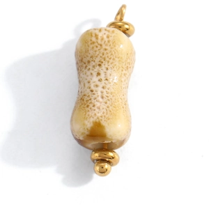 Macro detail of peanut shaped pendant with realistic texture and golden ring attachments