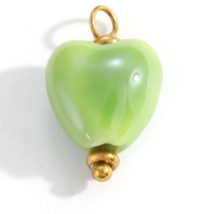 Close-up of heart-shaped light green glass pendant with golden metal hanging loop detail