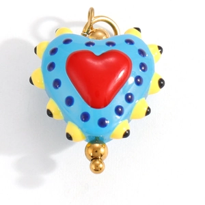 Macro shot of blue enamel heart pendant with yellow spikes and golden jump ring