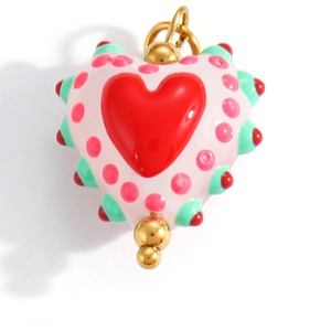 Macro view of a colorful heart pendant with pink enamel and green textured edges