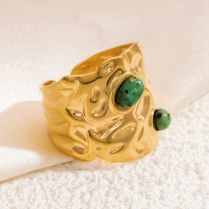 Close-up of vintage wide 18K gold plated ring with turquoise stones and lava texture