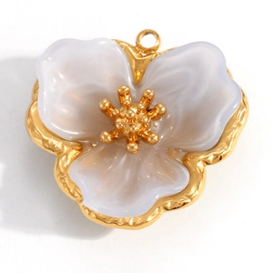 Detail eines 18K vergoldeten Blumenanhängers mit weißen Blütenblättern und Aufhängeschleife