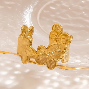 Elegant gold starfish ring with natural stone inlay on a textured wave background