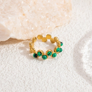 Gros plan sur bague dorée ajustable ornée de six perles de malachite verte